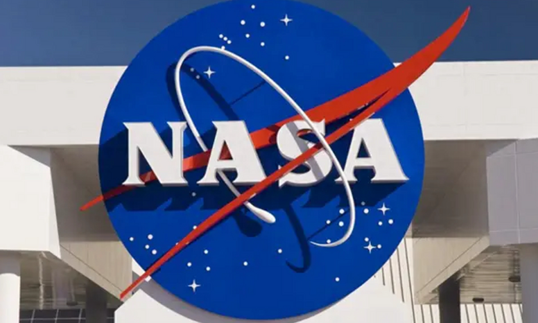 The image showcases the iconic logo of the National Aeronautics and Space Administration (NASA). The logo is prominently displayed on the exterior of a building. It features a large, circular blue background with the acronym "NASA" in bold, white, capital letters at its centre. Superimposed on the circle are two dynamic, diagonal stripes: a red one sweeping from the lower left to the upper right and a white one forming an elliptical - like shape that intersects with the red stripe. Additionally, there are small white star - like symbols scattered across the blue background, evoking a sense of the vastness of space. The overall design conveys a sense of innovation, exploration, and the cutting - edge nature of NASA's space - related endeavors.